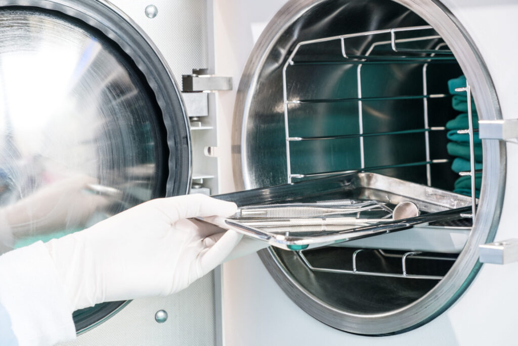 Hand reaching into sterilizing machine.